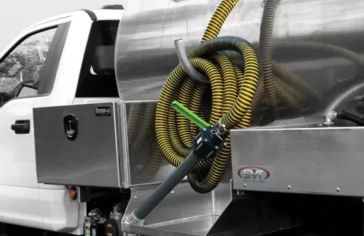 Close-up of a white industrial truck with a metal tank and coiled yellow and black hoses mounted on the back.