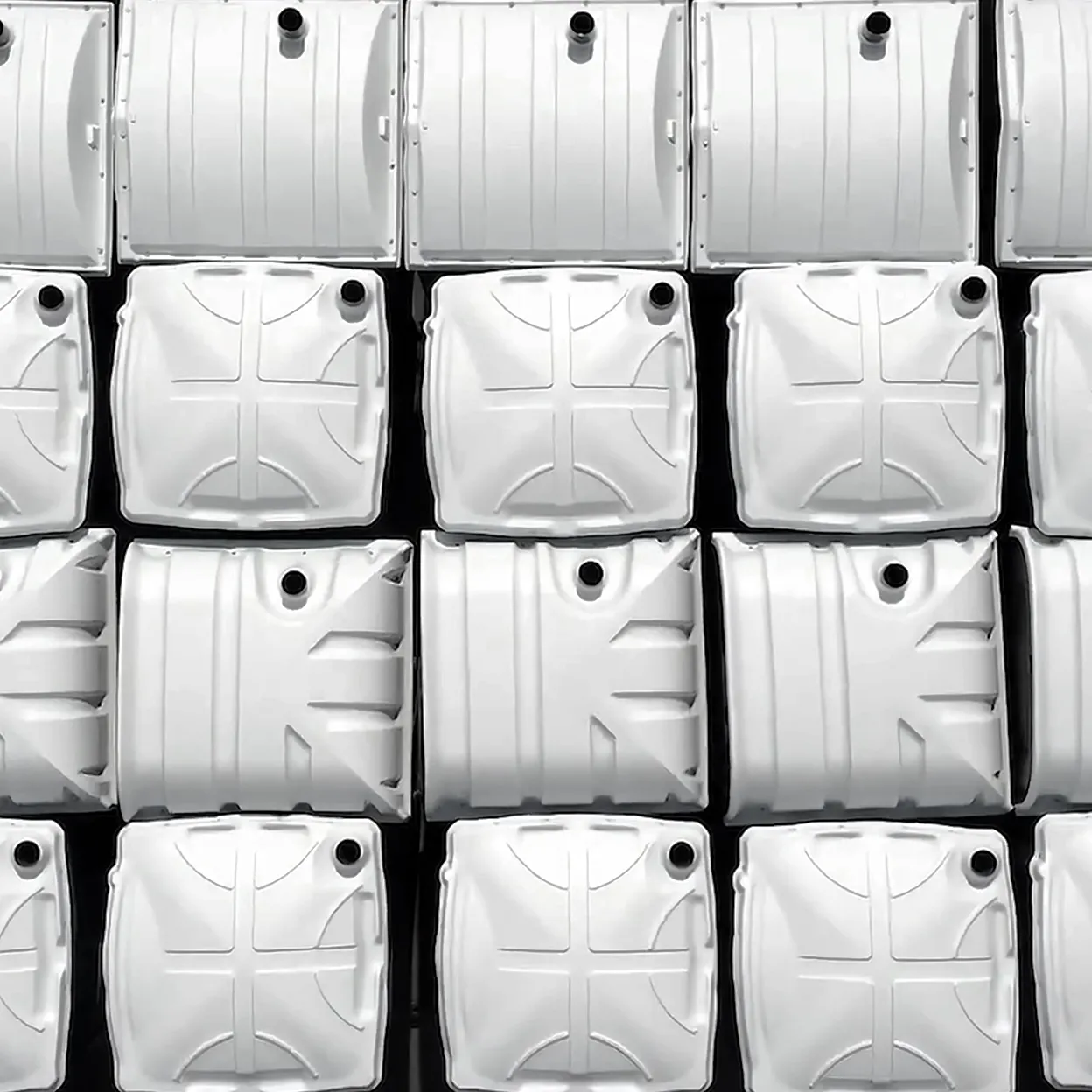 Stacked white plastic tanks with circular inlet openings viewed from above
