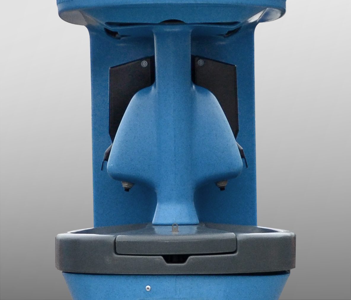 A blue public toilet with a streamlined design and a gray base, featuring a flush mechanism.