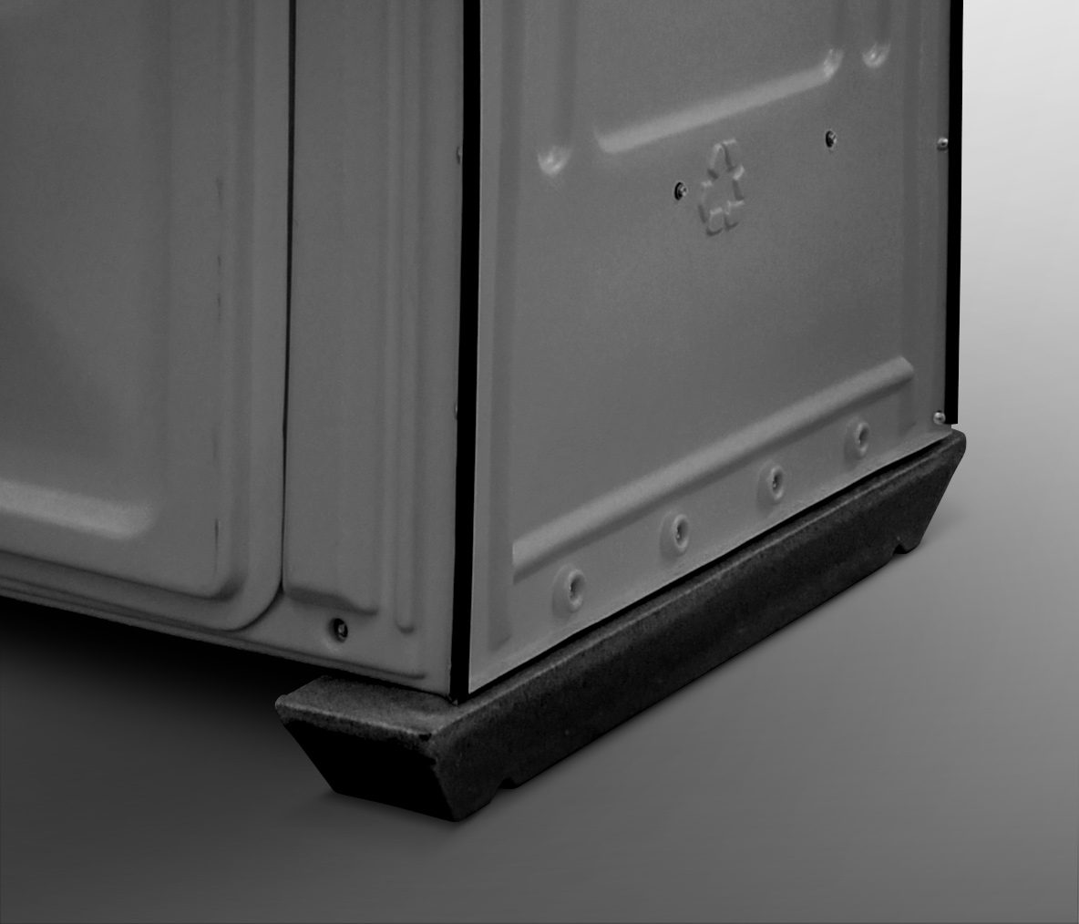 A close-up of the lower corner of a gray metal container, featuring a black rubber edge and