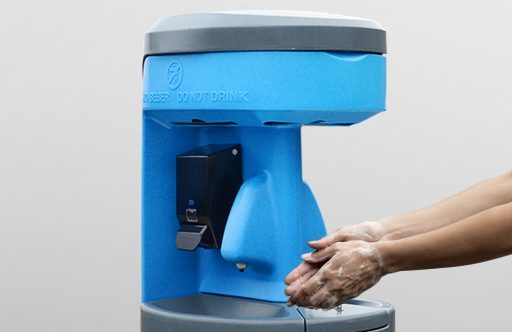 A blue handwashing station with a dispenser, showing hands being washed with soap.